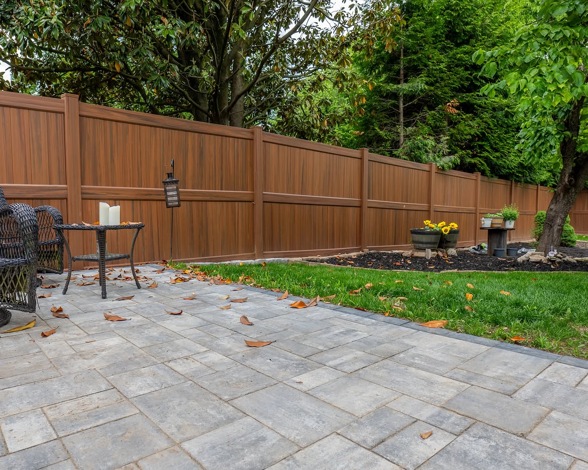 Full view of brown vinyl privacy fence and paver patio in North Wilmington, DE