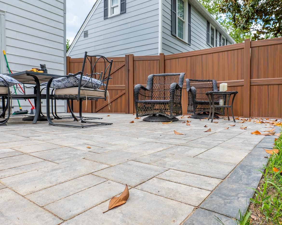 Angled view of brown vinyl privacy fence and paver patio in North Wilmington, DE