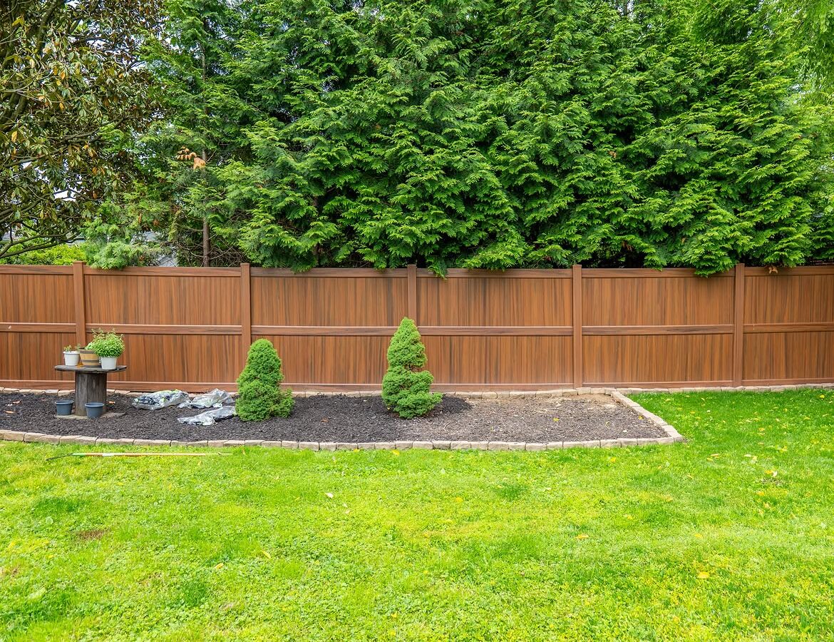 Side view of brown vinyl privacy fence and paver patio in North Wilmington, DE