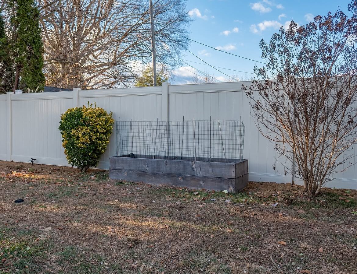 Angled view of cream vinyl privacy fence in Delaware