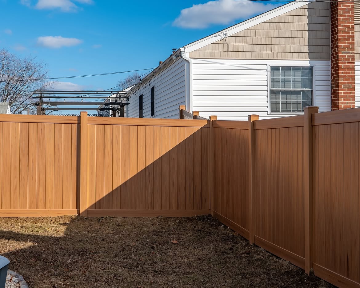 Side view of light tan wood grain vinyl fence in Aston, PA