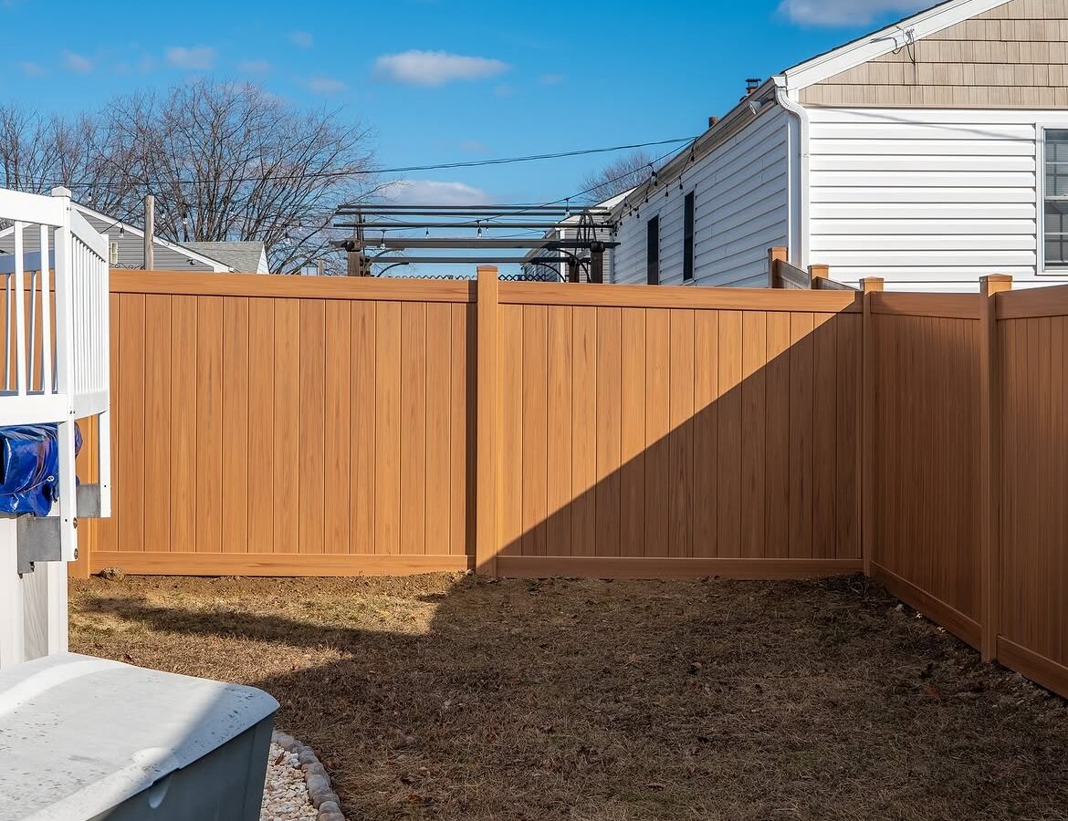Close-up of light tan wood grain vinyl fence in Aston, PA