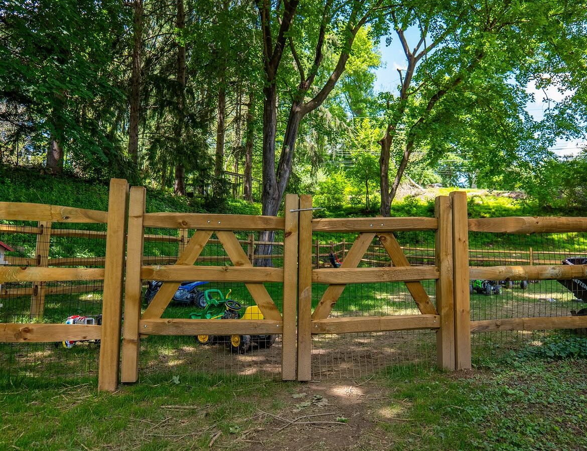 Full view of wood post-and-rail fence with wire mesh in Delaware