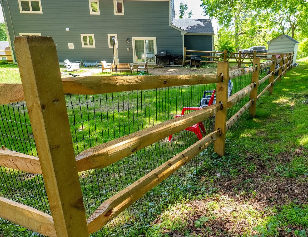 Property line view of wood post-and-rail fence with wire mesh in Delaware