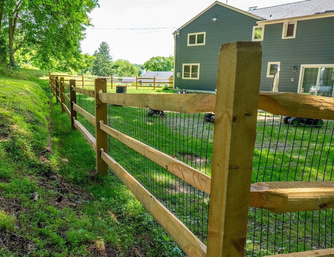 Side view of wood post-and-rail fence with wire mesh in Delaware