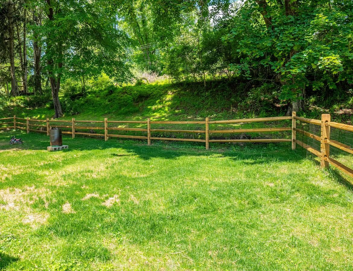 Wide view of wood post-and-rail fence with wire mesh in Delaware