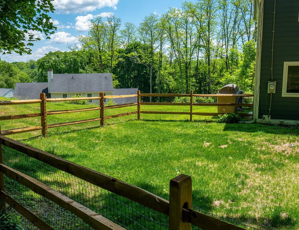 Rear yard view of wood post-and-rail fence with wire mesh in Delaware