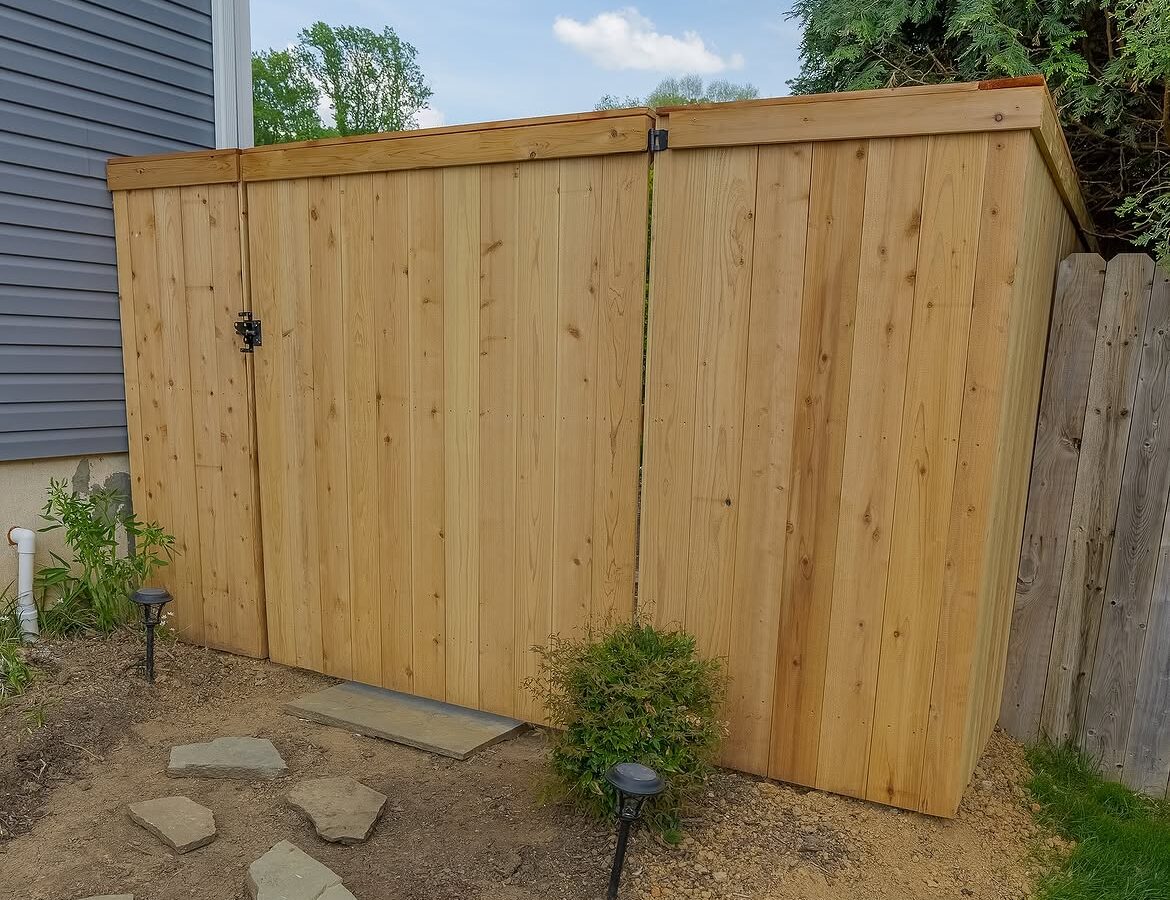 Open gate view of red cedar cap and trim fence in Delaware