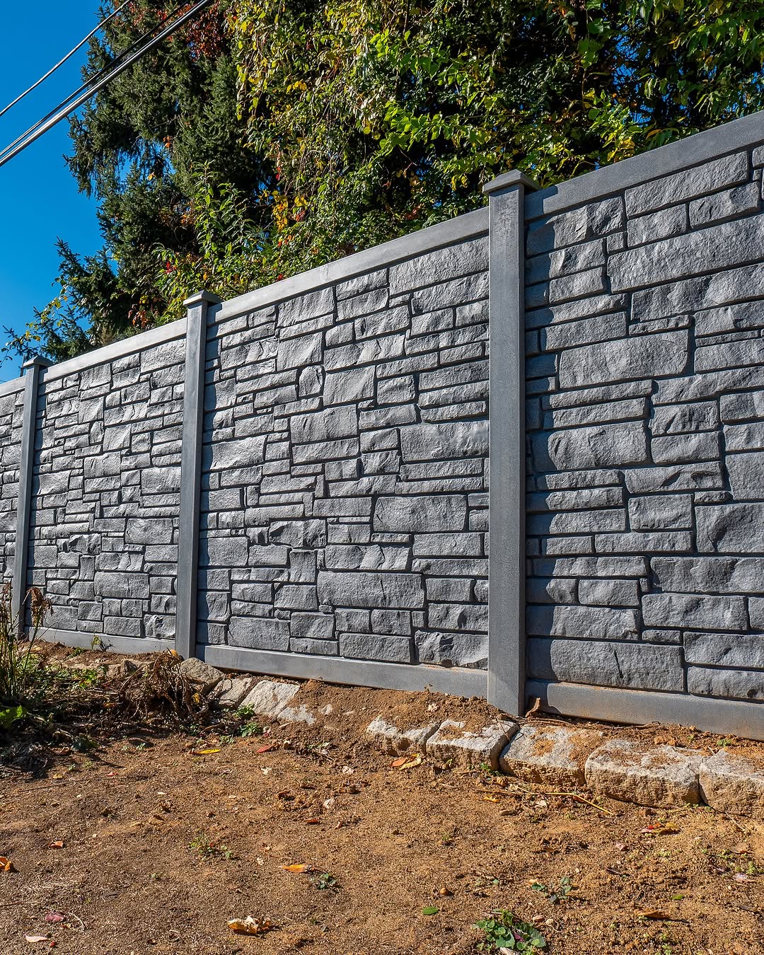 Full view of rock wall vinyl privacy fence in Delaware