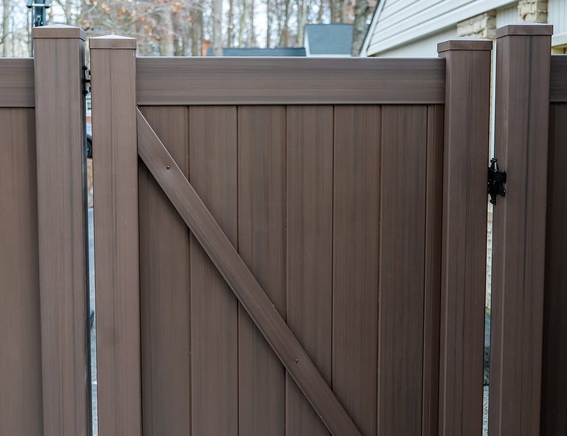 Gate and fence view of tan and brown wood grain vinyl fence in Delaware