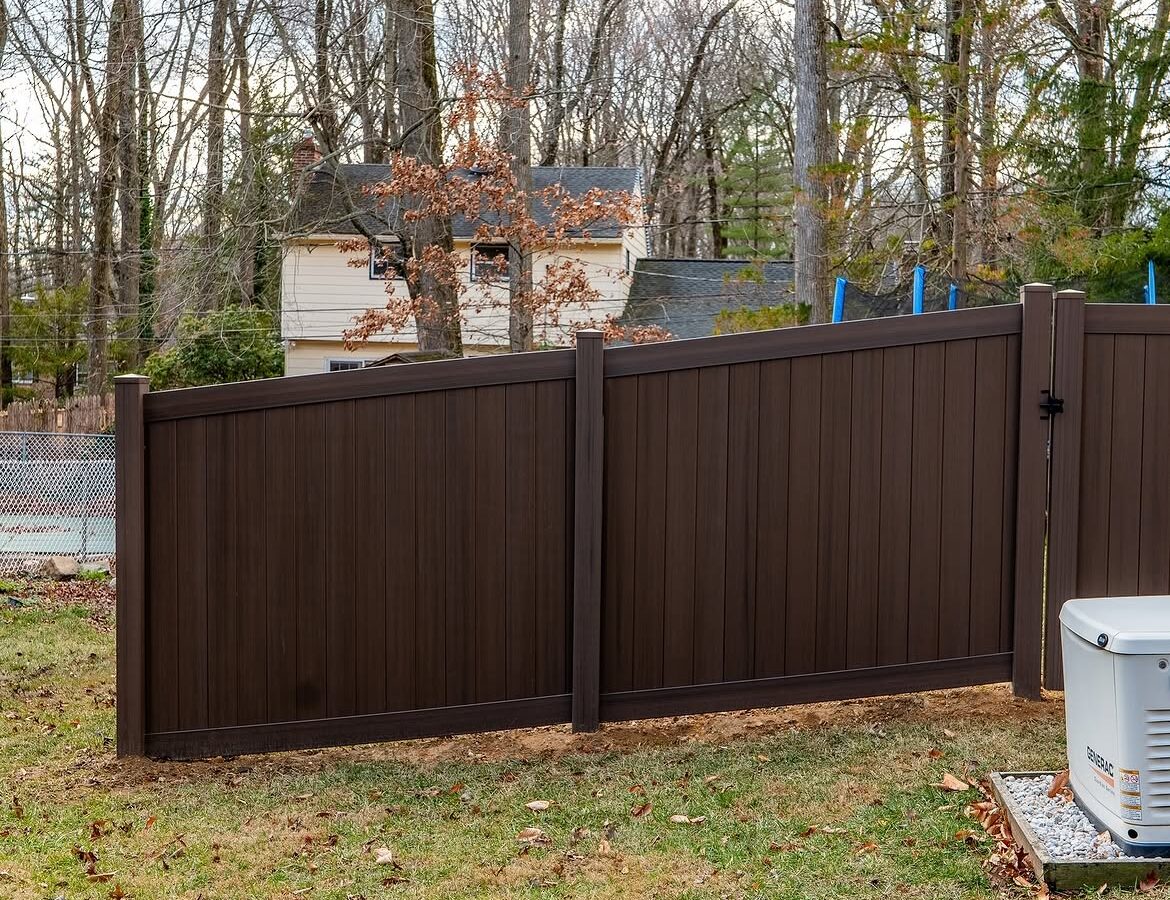 Open gate view of tan and brown wood grain vinyl fence in Delaware