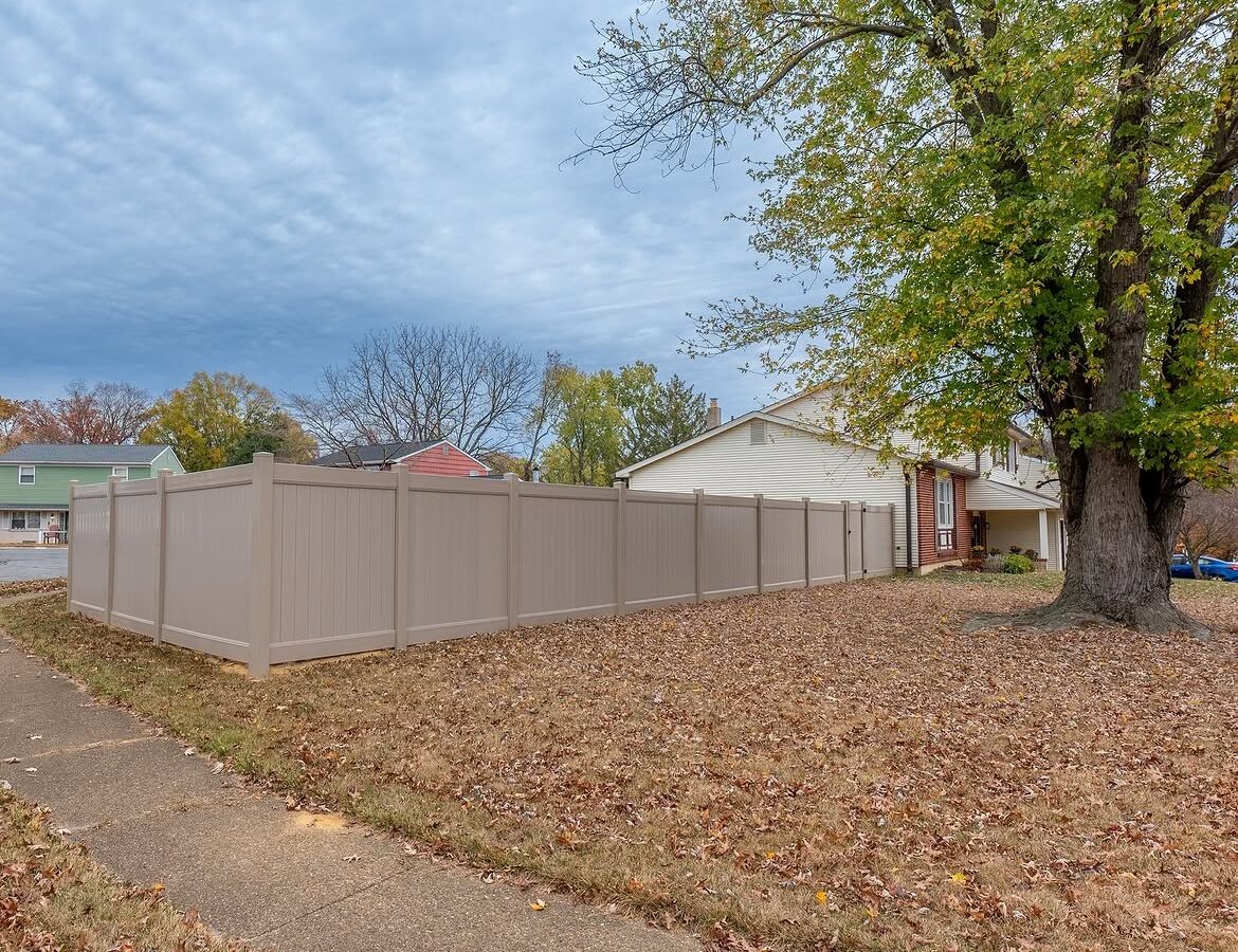 Property line view of tan vinyl privacy fence in Delaware