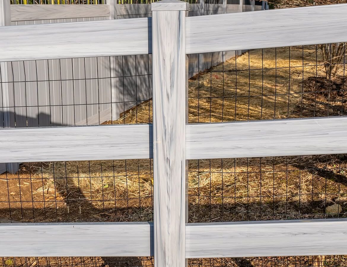 Property line view of vinyl ranch rail and privacy fence in Delaware