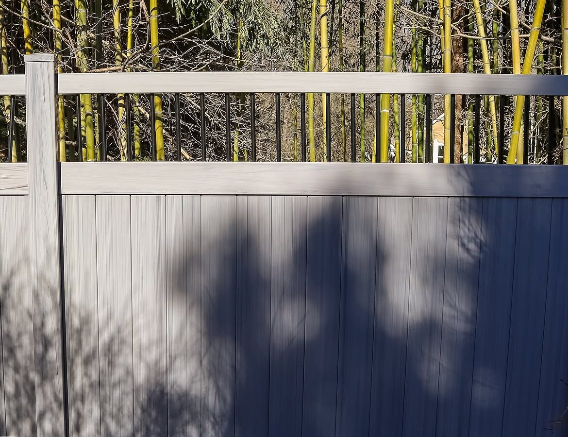 Curbside view of vinyl ranch rail and privacy fence in Delaware