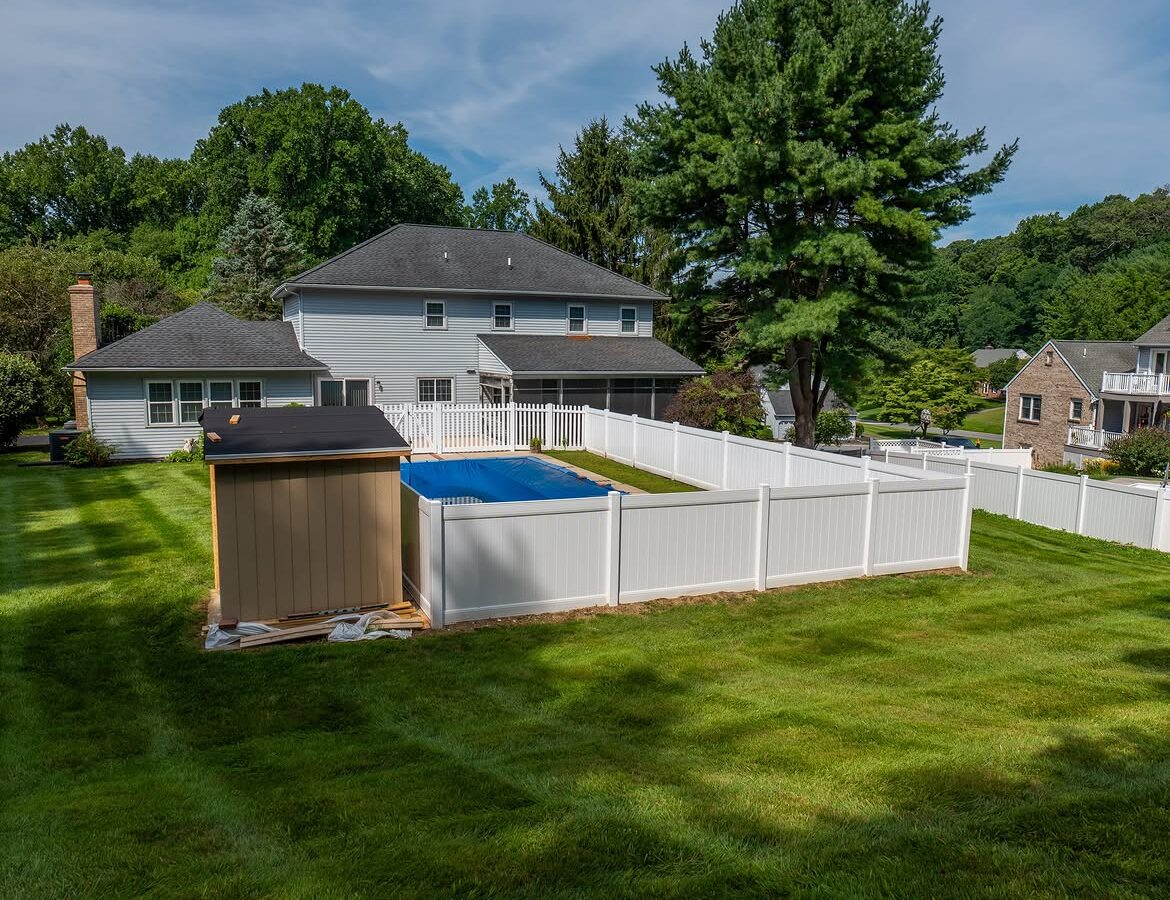 Wide view of white vinyl pool fence in Delaware