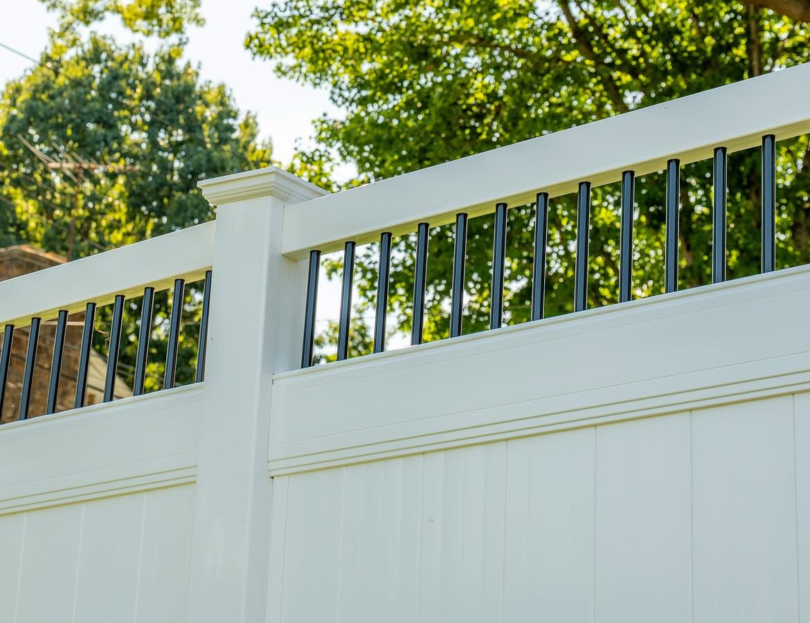 Property line view of white vinyl fence with aluminum accents in Delaware