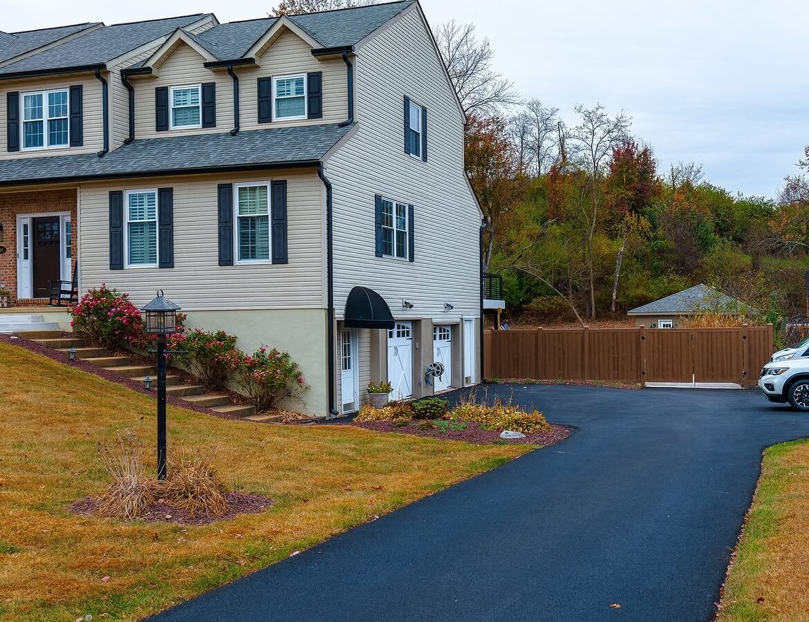 Gate and fence view of wood grain vinyl driveway gate in Delaware