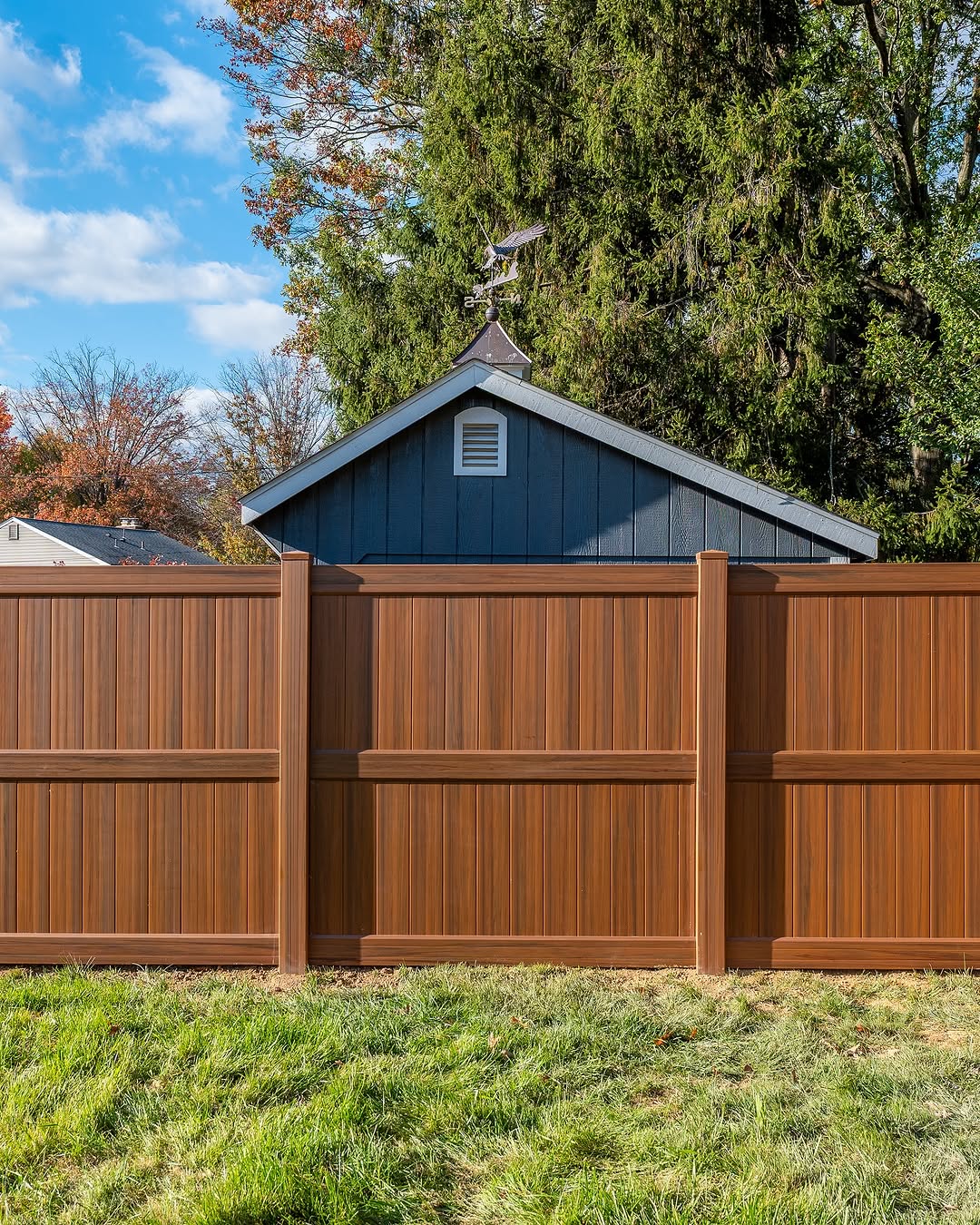 Full view of wood grain vinyl privacy fence in Delaware