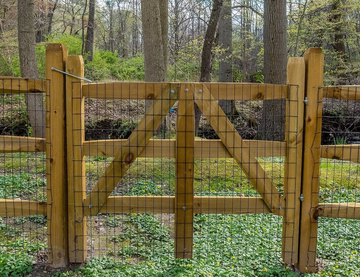 Gate and fence view of wood post-and-rail fence in Delaware