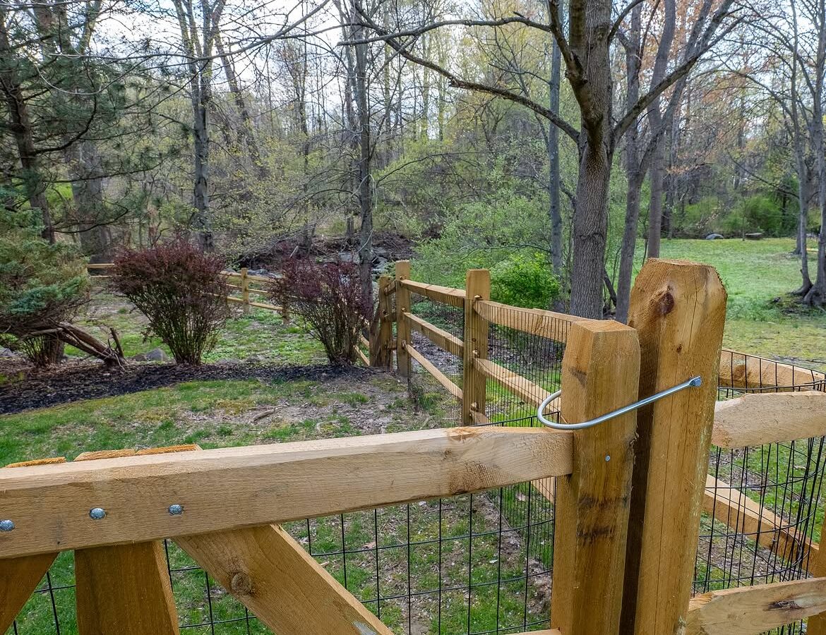 Open gate view of wood post-and-rail fence in Delaware