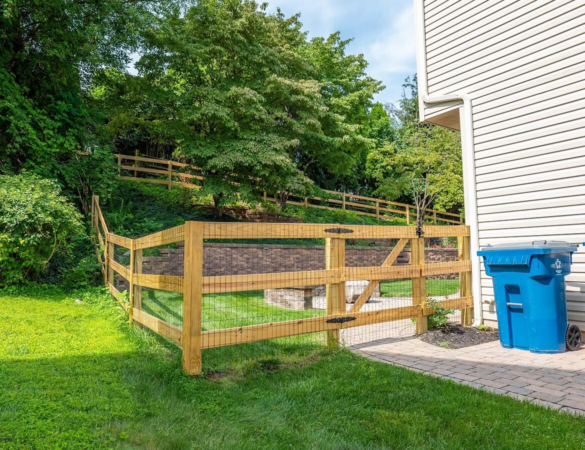 Full view of wood post-and-rail fence, paver patio and retaining wall in Delaware