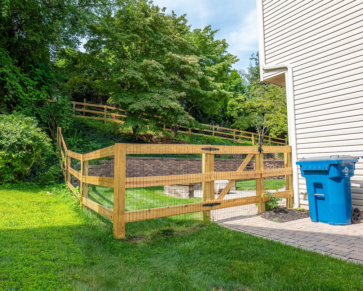 Full view of wood post-and-rail fence, paver patio and retaining wall in Delaware