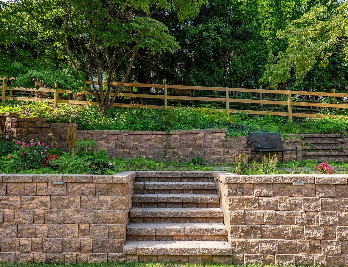 Angled view of wood post-and-rail fence, paver patio and retaining wall in Delaware