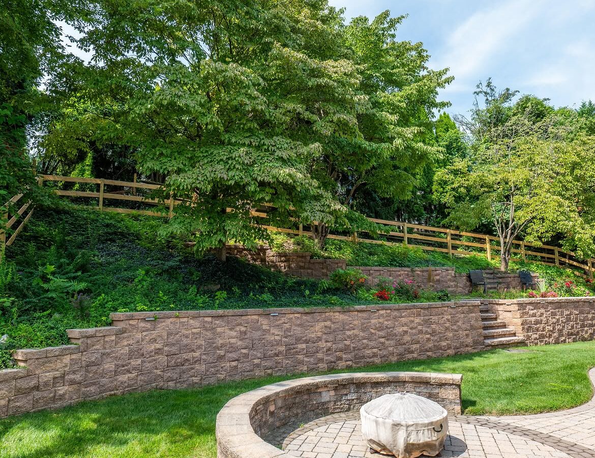 Corner detail of wood post-and-rail fence, paver patio and retaining wall in Delaware